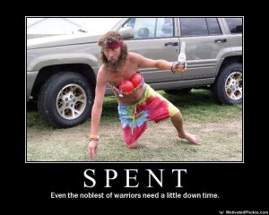 A bearded man in a colorful outfit poses with a drink beside an SUV under “SPENT,” with text saying even warriors need a little down time.